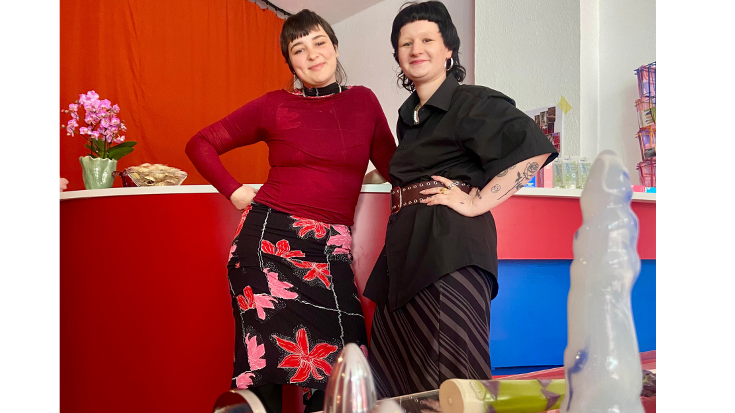 Sextoys Zwei Mädchen stehen neben verschiedenen Sextoys