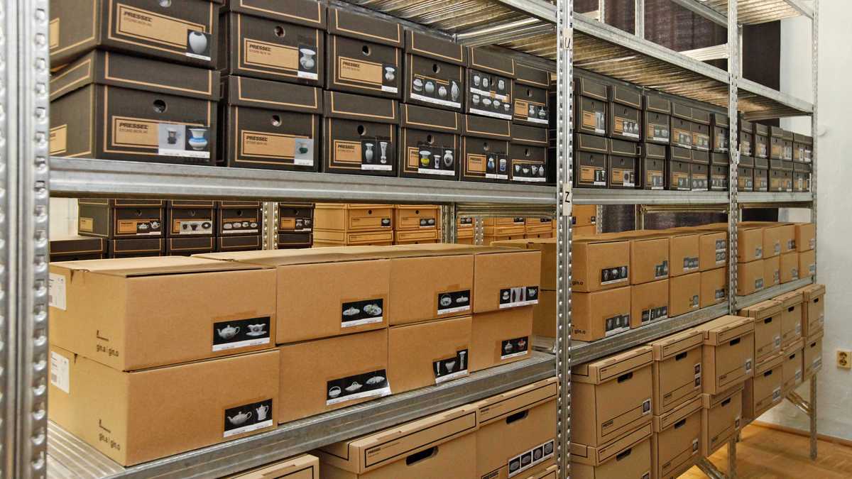 Sammlung Metallregal mit vielen Kartons, in denen Porzellanteile lagern