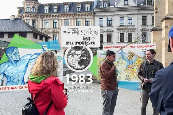 Digitales Exponat "Umweltausstellung 1983" schwebt hinter der Marktkirche, dazwischen Menschen