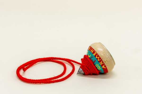 Wurfkreisel "Hol" bemalter Holzkreisel mit Metalspitze und aufgewickelter Schnur