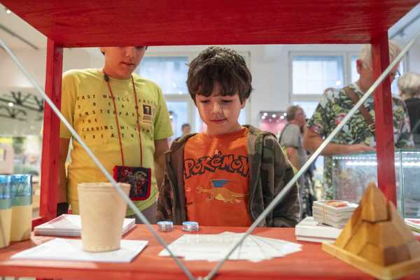 Brettspiele Der Junge sieht sich eine Ausstellung "Spiel weiter!" an. Vor ihm stehen die Brettspiele.