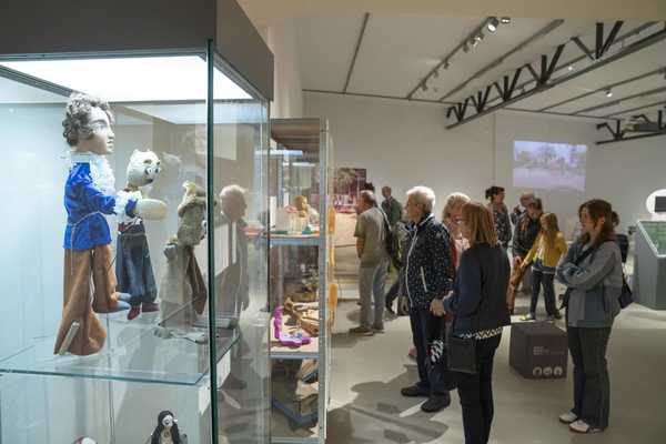 Armenische Puppen Die Leute schauen sich die Ausstellung an. Im vordergrund: von armenischen Handwerkern hergestellte Puppen.