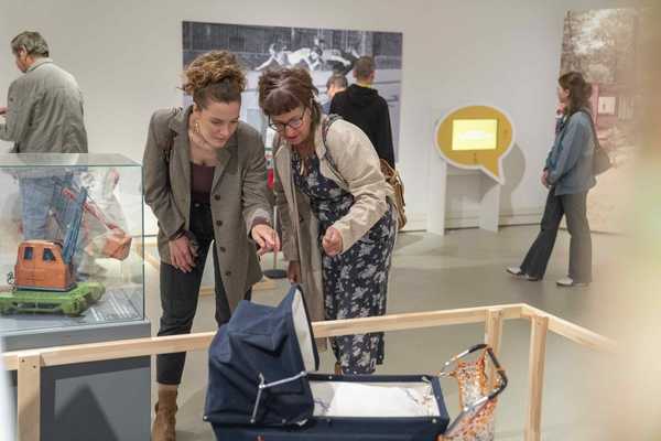Kinderwagen Spielzeug Zwei Frauen schauen sich einen Spielzeugkinderwagen an.